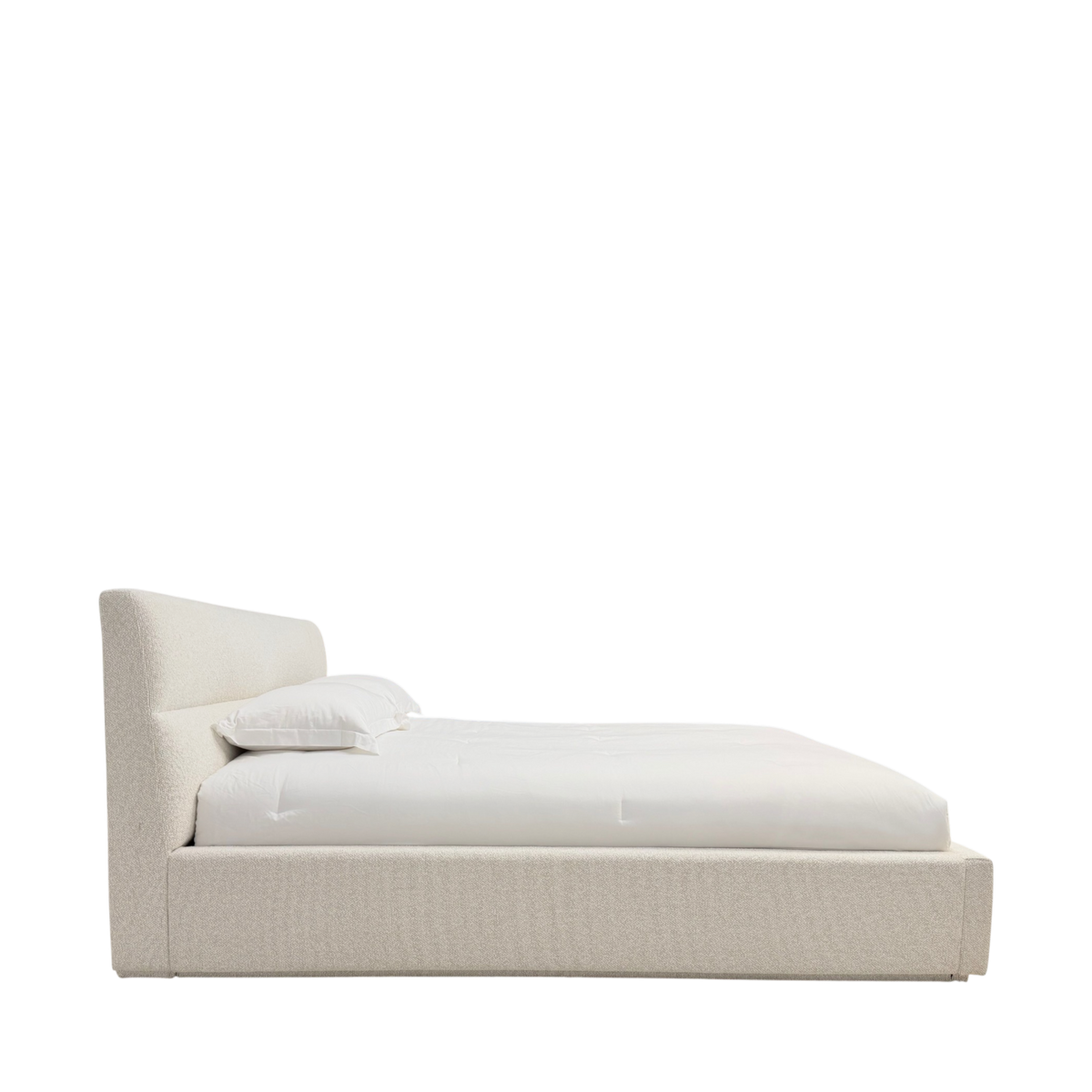 Side view of Pearson King Bed showing the low upholstered platform and gently reclined headboard in Lisa Cream.
