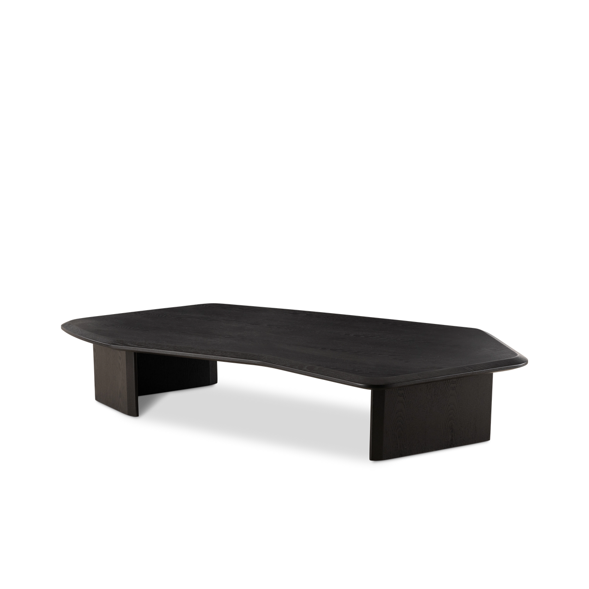 Gemini Coffee Table angled from the front in black ash, highlighting the angular top, curved notch along one side, and two solid slab legs.