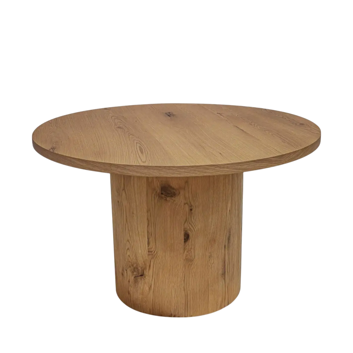 Weaver Dining Table in warm wood with a round top and cylindrical pedestal base, shown from an angled front view.