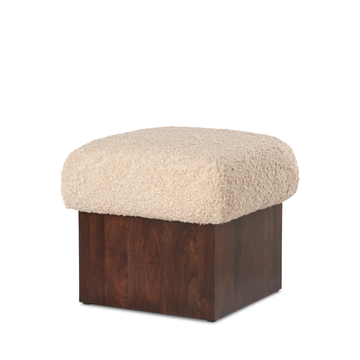 Ciro Ottoman in an angled view in cream faux shearling and dark brown mango wood, highlighting the softly rounded cushion edges and the square plinth base.