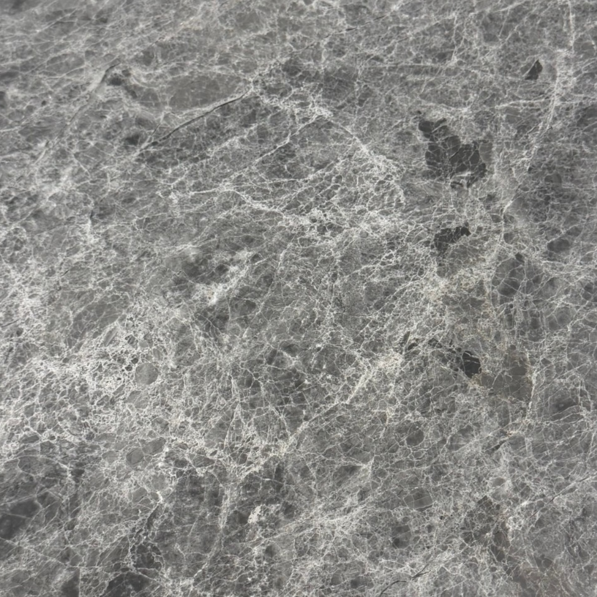 Bento Table. Gray marble texture with white veining and dark gray to black mineral inclusions.