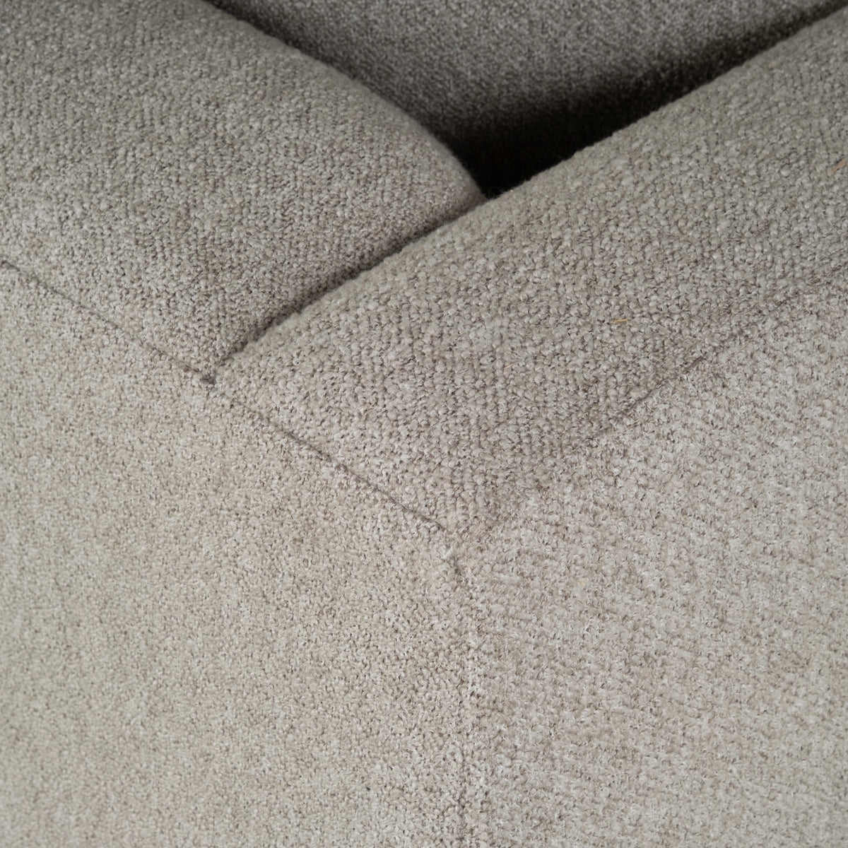 Close-up highlighting the stitched seam where the arm meets the seat on the Ease Sofa in Pebble textured fabric, with a subtle V-shaped seam line.