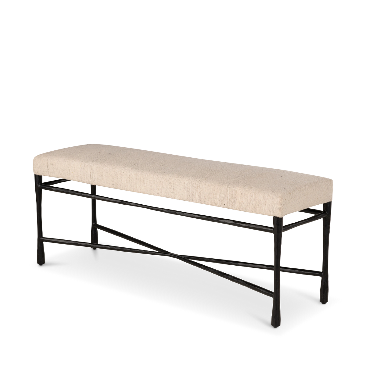 Trevino Bench shown from an angled view with a long natural upholstered seat and sculptural dark metal base.