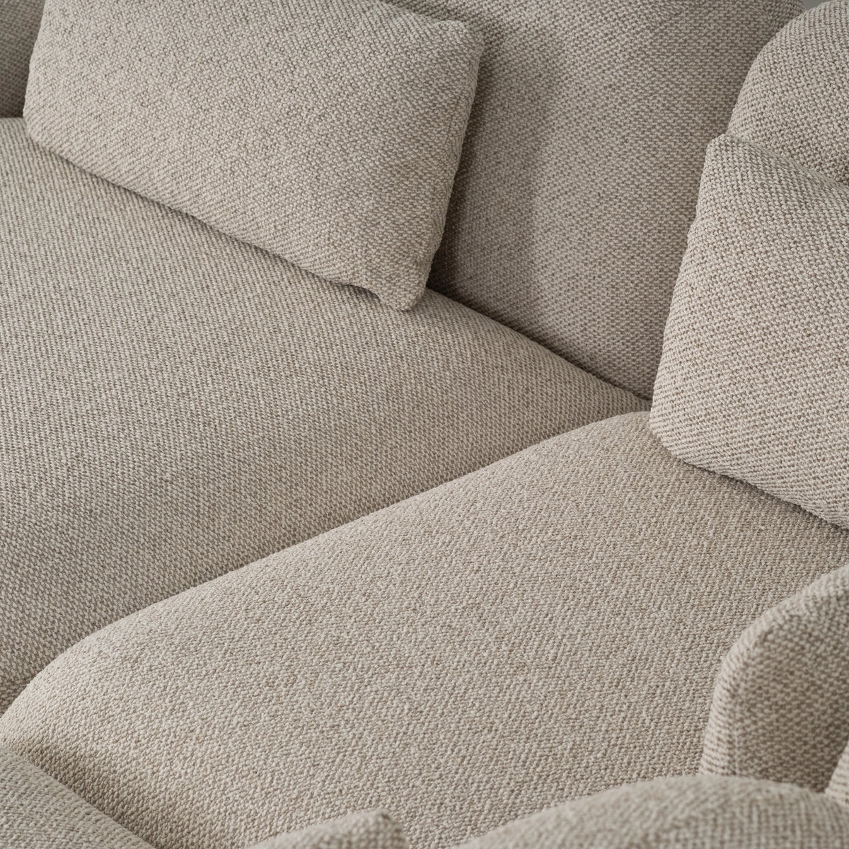 Top-down detail of the Duncan Modular Sectional in Oatmeal tweedy weave, showing deep seats, lumbar pillows and the rounded arm edge.