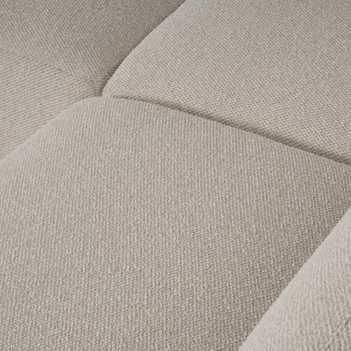 Close-up of the Arlo Modular Sectional’s seat and back cushions in Oatmeal woven fabric, showing the soft channel between sections and a fine, flecked weave.