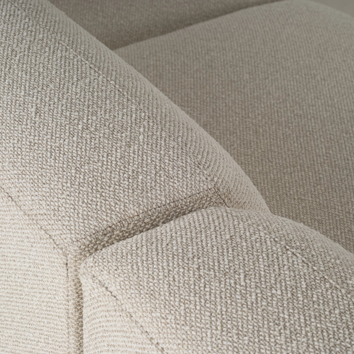 Close-up of the Arlo Modular Sectional’s rounded cushion edge and piped seam in Oatmeal woven fabric, highlighting the tight, flecked texture.