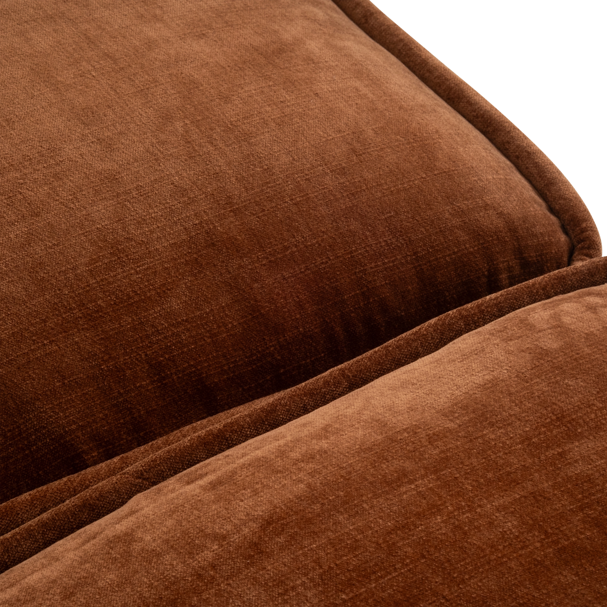 Close-up of the Loom Modular Sectional in rust chenille, showing the piped edge of the back cushion resting against the seat cushion with a soft, streaked pile.