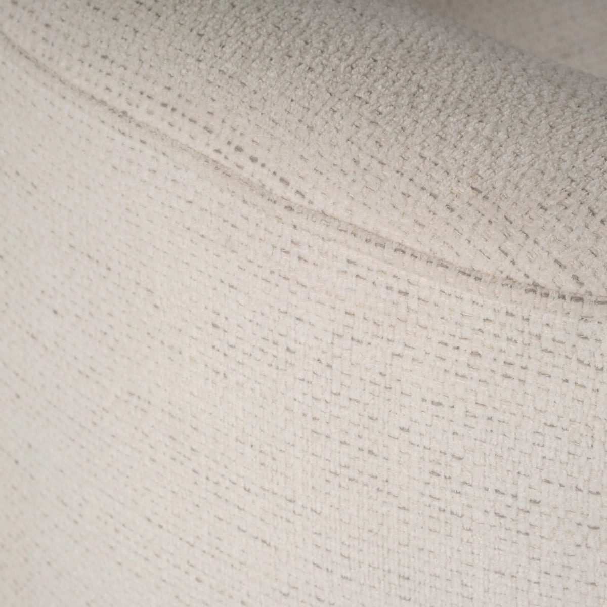 Rowe Swivel Chair in Natural woven fabric shown in close-up along the curved back, with a seam line running through the nubby weave.