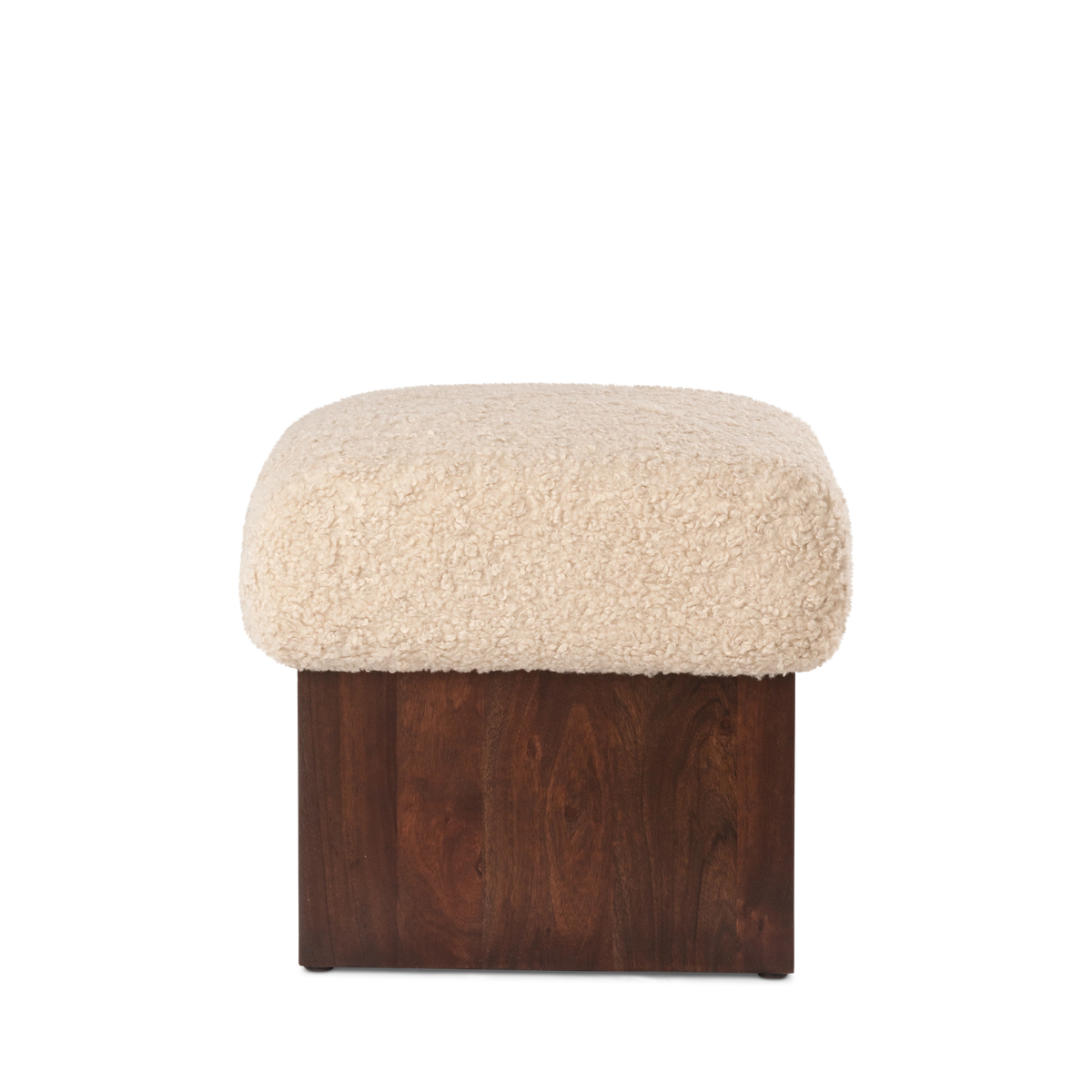 Ciro Ottoman shown from the front in cream faux shearling with a dark brown mango wood base, highlighting the plush overhanging cushion and visible wood grain.