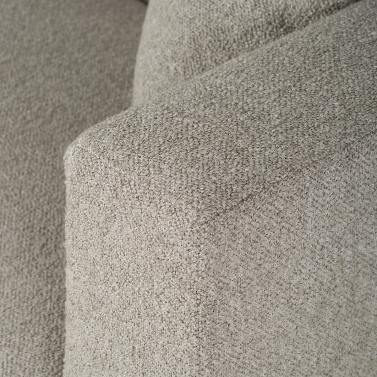 Ease Sofa in Pebble textured fabric shown in close-up along the square arm, with a crisp edge and a nubby, woven texture.