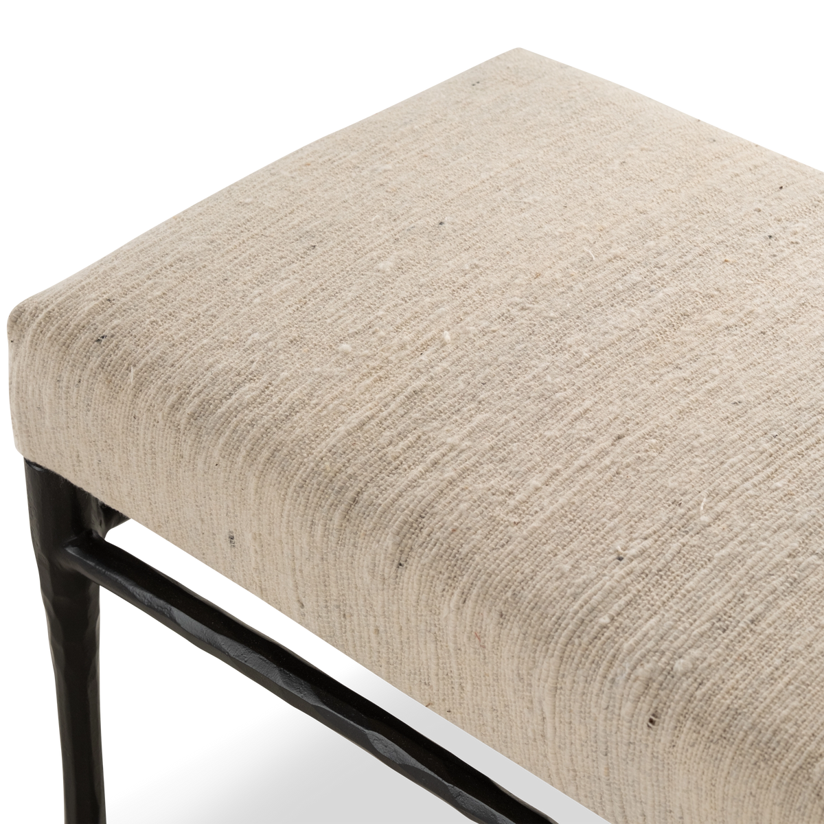 Trevino Bench detail showing the softly rounded upholstered seat and dark metal support frame.